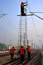 中铁电气化局的工人在宜万铁路上推着梯车调试线路